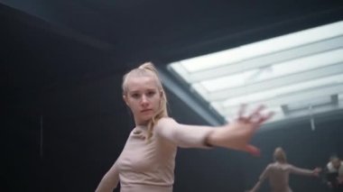 Genç bir kadın ayna odasında ışık hatlarıyla dans ediyor. Esnek bir kadın yoga elementleriyle esneme dansı yapıyor..