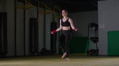 Konsantrasyon, boks ve koordinasyon eğitimi, genç bir kadın boksör ipe atlıyor, güçlü bir vücut..