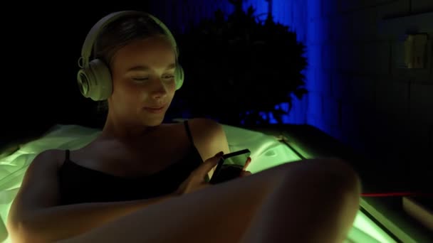 Ładna Kobieta Odtwarzaczem Audio Słuchawkami Leży Komorze Deprywacji Sensorycznej Neonowe — Wideo stockowe