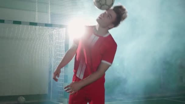 プロサッカー選手はサッカーボールでトリックを行い 男は頭のボール 映画ライト 4Kの遅い動きのバランスをとります — ストック動画