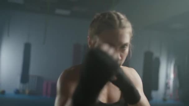 女性のパワー 若い女性戦闘機は彼のパンチを訓練し ボクシングジムでトレーニング 女性の列車は速い一連のパンチ — ストック動画