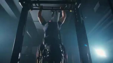 Belarus, Minsk - 24 Eylül 2021: Tekerlekli sandalyedeki engelli sporcu, yatay barfiks, beden eğitimi ve fiziksel aktivitede barfiks çekiyor..