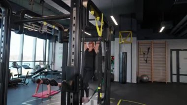 Belarus, Minsk - 3 Nisan 2022: Spor salonunda sporcular spor yapıyor, spor salonundaki yatay barda şınav çekiyor ve barfiks çekiyor..