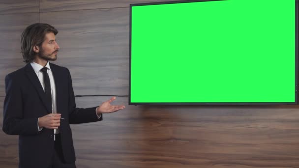 商务会议上 一位年轻的商人在会上讲了话 并在会议室里展示了演讲 电视上有绿色屏幕 有色键 穿西装的男人与同事交流 — 图库视频影像