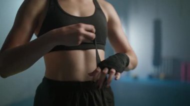 Kadın dövüşçü ellerini boks bandajlarıyla sarar, spor salonunda kickboks antrenmanı yapar, kadın dövüşçü savaşa hazırlanır, kadın gücü..