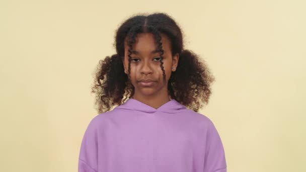 ゆっくりとした動き 暗い皮をむいた少女の肖像画 10代の少女はカメラを見て 目を閉じて 深刻な外観 顔の特徴 ベージュの背景 — ストック動画