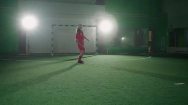 Profesyonel futbolcu futbol topuyla numaralar yapar, topu kafasında dengeler..