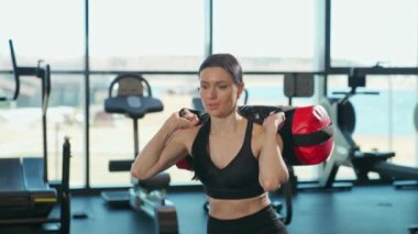 Kadın gücü, atletik kadın ağırlıklarla çömelme hareketleri spor salonunda kas antrenmanı, bacak kasları, motivasyon, 4k ağır çekim..