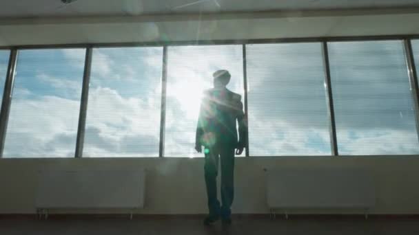 ビジネスモチベーション ビジネスマンは パノラマウィンドウの前に立って モダンなオフィスで朝 自然照明 思考プロセス バックビュー — ストック動画