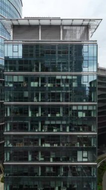 Şehir manzarası modern ofis binası, iş merkezi, trafik binanın cam cephesine yansıyor, ofis içleri camdan görünüyor, dikey video, şehir merkezi..