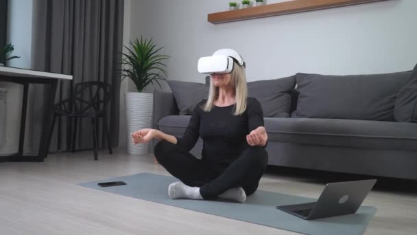 Een Oudere Vrouw Virtual Reality Bril Mediteert Woonkamer Moderne Technologie — Stockvideo