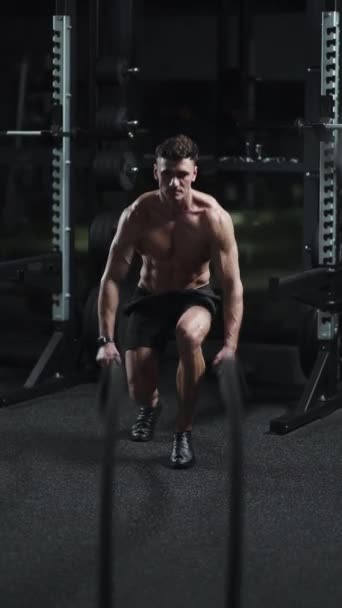 Atletik Adam Dövüş Halatlarıyla Spor Salonunda Dayanıklılık Eğitimiyle Sinematik Işıkla — Stok video