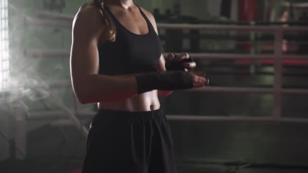 女拳击手用拳击绷带包住双手 在体育馆里练跆拳道 点燃霓虹灯 — 图库视频影像