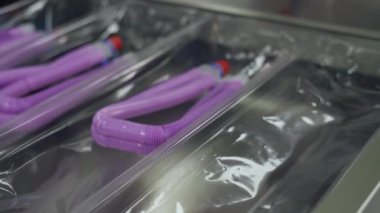 Tıbbi oksijen teçhizatı üretimi, çalışan kadın, nefes alma ekipmanları için plastik tüpler paketleme süreci..