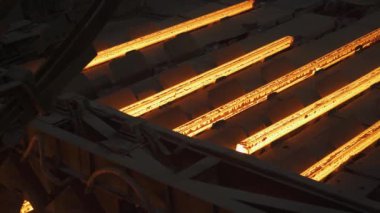Çelik yapımı, çelik çubuklar ve boru üretimi, üretim hattında taşınan kırmızı sıcak borular, ağır sanayi, yuvarlanan metal fabrikası.
