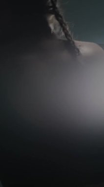 Sportif kadın boks salonunda yumruklarını ve savunmasını eğitiyor, kız hızlı saldırıyor, kum torbasına vuruyor, hafif hafif, dikey video..