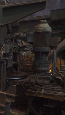 Çelik fabrikası, dikey video, çelik boru üretimi, üretim hattında taşınan kırmızı-sıcak boru, ağır sanayi, yuvarlanan metal fabrikası..