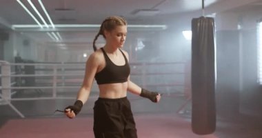 Kadın boksör antrenmanları ve ip atlama, koordinasyon eğitimi, boks salonunda kickboks antrenmanı, formda vücut, deniz mavisi ve turuncu.