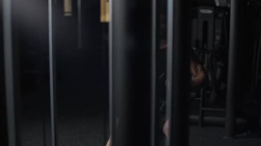 Yavaş çekim, spor salonundaki sporcu kürek çekme makinesindeki blokları kaldırıyor, bloklama cihazı ve geceleri spor aletleri eğitimi alıyor..