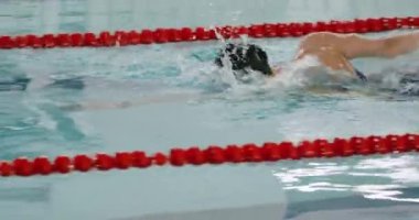 Genç profesyonel bayan yüzücü havuzda yüzüyor, kadın suda yüzüyor ve antrenman yapıyor..