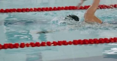Young professional female swimmer swims in the pool, woman swimming and training in the water, slow motion.