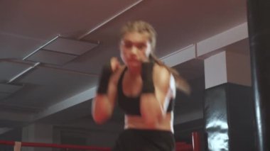 Kadın gücü, kadın dövüşçü boks salonunda yumruklarını ve savunmasını eğitiyor, kadın yumruk serisi eğitiyor, ön görüş..