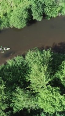 Dikey video, nehirde rafting, yükseklikten kano manzarası, orman bölgesinde nehirde yüzen kaşiflerden oluşan bir ekip, ekoloji..