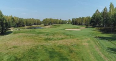 Yaz güneşli bir gün, orman bölgesindeki golf sahasının havadan görünüşü, golf kulübü, ormanın yakınındaki yeşil çimlerin manzarası..