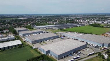 Varşova, Polonya - 25 Haziran 2024: Konut alanı yakınlarındaki lojistik merkezi, depo binaları, kargo taşımacılığı, hava manzarası yakınlarındaki çok sayıda kargo römorku ve kamyonun görüntüsü.