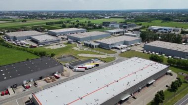 Varşova, Polonya - 29 Haziran 2024: Konut alanı yakınlarındaki depolar, lojistik merkezi, depo binaları, kargo taşımacılığı, hava manzaralı çok sayıda kargo römorku ve kamyon manzarası.