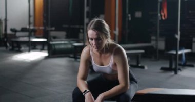 Spor salonundaki egzersizden sonra dinlenen genç ve güzel bir kadın. Egzersiz üstüne yorgunluk..