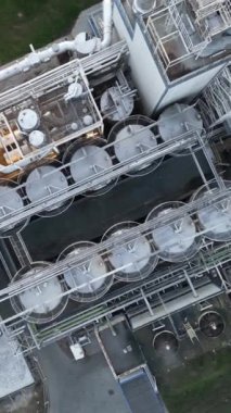 Endüstriyel arazi, büyük işleme fabrikası, çelik boruların ve tankların yükseklikten görünüşü, fabrikanın endüstriyel yapısı, dikey video.