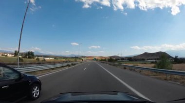 EUROPE - 30 Ağustos 2019: Avrupa 'ya yolculuk, otoyolda giden bir arabanın birinci şahıs görüntüsü, yaz dağları doğal manzara, yol trafiği.