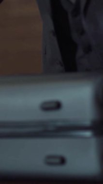 Takım elbiseli genç işadamı içinde kıyafet, iş gezisi, otel odası içi, dikey video olan bir bavulu açıyor..