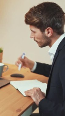 Evdeki uzak bir işe odaklanmış bir adam, belgelerle ve mali beyannamelerle çalışıyor, öğrenim süreci, dikey video.