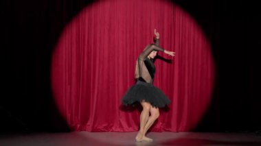 Dramatik performans, siyah etekli güzel balerin kırmızı arka planda dramatik dans gösterisi, sahne ışığı, güzel dans.