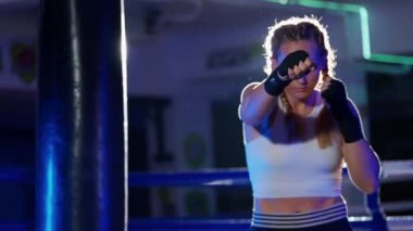 Kadın boksör yumruklarını, spor salonunda kadın antrenmanlarını boks antrenmanlarını boks dövüşçüleri bir dizi yumruk, ön görüş, ağır çekim..