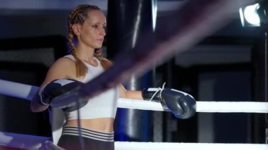 Süper yavaş çekim, ringin kenarında duran bir kadın dövüşçünün portresi, sıkı antrenman ve idman için hazırlanıyor, kadın gücü..