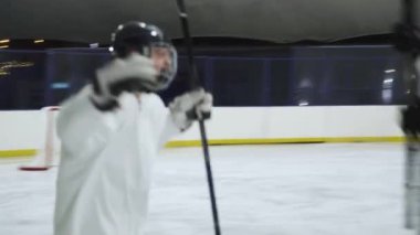 Belarus, Minsk - 29 Kasım 2021: Profesyonel hokey oyuncuları maçtaki zafere seviniyor, beyaz hokey üniformalı takım sarılıyor ve kutluyor.