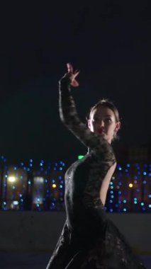 Dikey video, buzda dans, buz üstünde güzel kadın jimnastikçi, buz üstünde dans eden kadın, buz pateni.