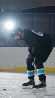 Ağır çekimler, yarışmalar, koruyucu kıyafetli hokey oyuncusu hokey sahasında duruyor, sporcu vücudundan buhar çıkıyor, gergin anlar, kış sporları..