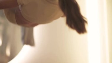 Aynalı odada yoga yapan bir kadın, sportif bir kadın kumaş iplerle ve el kamerasıyla odada esneme dansı yapıyor..