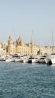Malta, Valletta - 22 Mart 2025: Eski kasabanın körfezindeki liman ve yatların güzel manzarası, mimari ve yat limanı, manzara, körfez manzaralı dikey video.