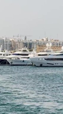Malta, Valletta - 22 Mart 2025: Eski kasabanın körfezindeki liman ve yatların güzel manzarası, mimari ve yat limanı, manzara, körfez manzaralı dikey video.
