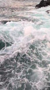 Doğa manzarası, güzel deniz manzarası, kayalara çarpan dalgalar, dikey video arka plan..