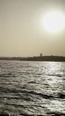 Güzel körfez manzarası, ufukta kasaba mimarisi, günbatımı video manzarası, gün batımında deniz manzarası..