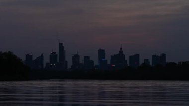 Varşova, Polonya - 17 Nisan 2025: Şehir manzarası, ufukta gökdelenler, göl ve şehir merkezi, bir gece vakti iş merkezi.