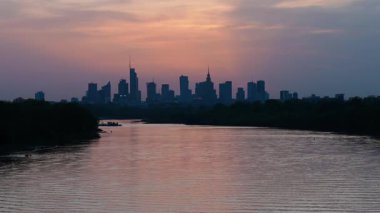 Varşova, Polonya - 17 Nisan 2025: Şehir manzarası gün batımı manzarası, ufukta gökdelenler, şehir nehri ve şehir merkezi manzarası, akşam saatlerinde iş merkezi.