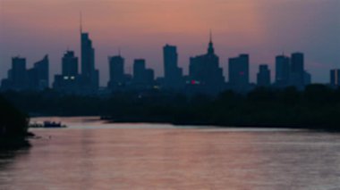 Gün batımı şehir manzarası bulanık, ufukta gökdelenler, şehir nehri ve şehir merkezi manzarası, akşam vakti iş merkezi.