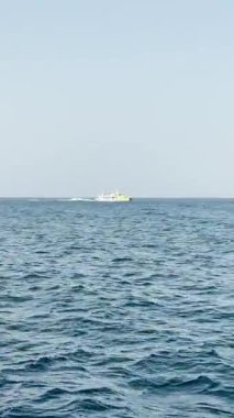 Malta, Valletta - 23 Mart 2025: Deniz manzaralı dikey video, denizde yüzen zevk teknesinin görüntüsü, manzara statik arka planı, Güney Avrupa.